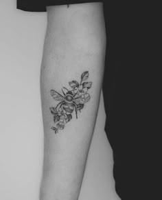 a black and white photo of a woman's arm with flowers on it