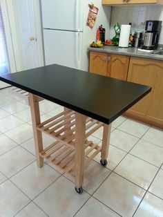 a kitchen island with wine rack on wheels in front of a refrigerator and countertop