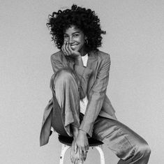 a black and white photo of a woman sitting on a chair