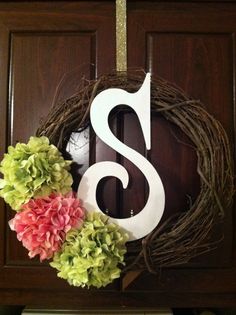 a wreath with the letter s and flowers on it