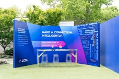 an exhibit booth with blue walls and purple signage on the wall that says make a connection, intelligentity