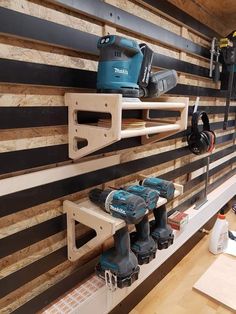 tools are lined up on the wall in this garage area with wood planks and black stripes