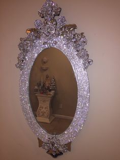 a mirror that is sitting on the wall in front of a table with a vase