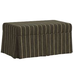 a brown and white striped ottoman with pleated skirting on the bottom, sitting in front of a white background