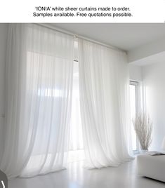 a white living room with sheer curtains on the windows