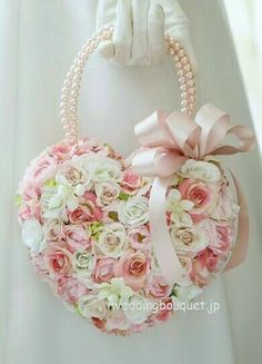 a heart shaped purse with pink roses and pearls