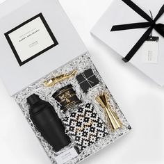 an open gift box with black and gold items