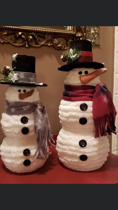 two snowmen with hats and scarves on their heads