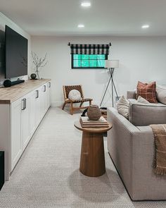 a living room filled with furniture and a flat screen tv mounted on the wall above it