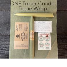 the one taper candle tissue wrap is next to it's packaging and instructions