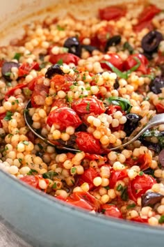 a pot filled with lots of food and a spoon full of some type of salad