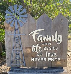 a wooden sign that says family where life begins and love never ends with a windmill