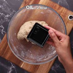 someone is mixing dough in a glass bowl