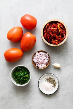 tomatoes, onions, and other ingredients are laid out on a table to be used as an appetizer