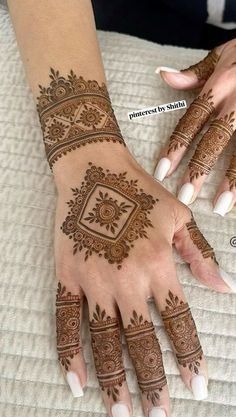 two hands with henna tattoos on them