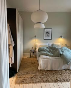 a bed sitting in a bedroom on top of a wooden floor next to a doorway