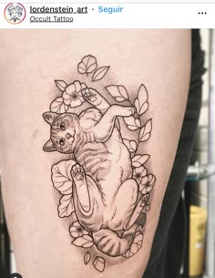 a tattoo on the leg of a woman with flowers and a cat sitting in it