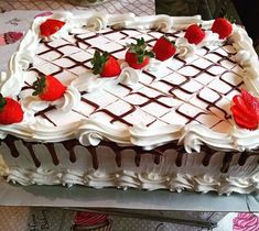 a large cake with chocolate and strawberries on top is ready to be cut into pieces