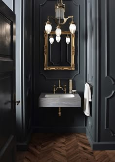 a bathroom with a sink, mirror and lights on the wall in front of it