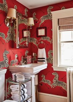 a bathroom with red walls and zebra wallpaper