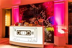 an old school record player in front of a wall with graffiti on it and pink lighting