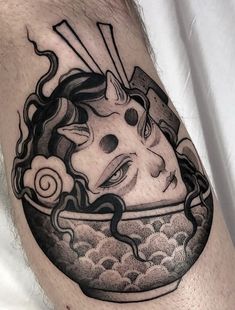 a man's leg with a black and white tattoo of a bowl of noodles