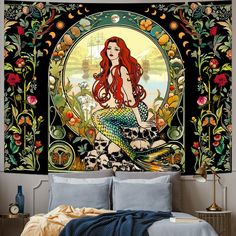 a mermaid sitting on top of a bed next to a wall hanging over it's head