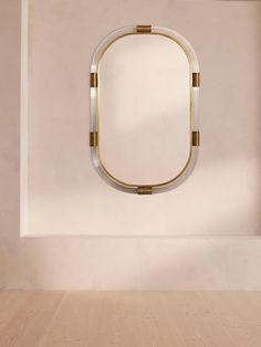 an empty room with a round mirror on the wall and wood flooring in front of it