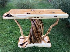 a bench made out of tree branches in the grass