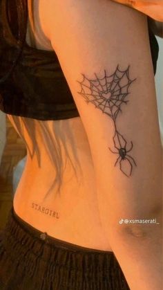 a woman with a spider web tattoo on her arm