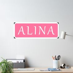 a pink name sticker on a white wall above a desk