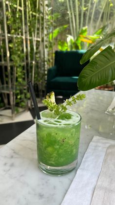 a green drink sitting on top of a table