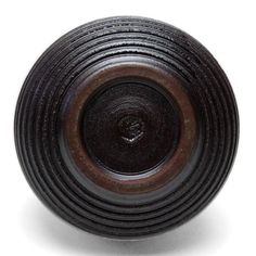 a black and brown knob on a white surface