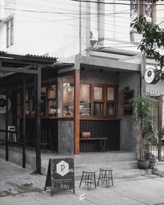 the outside of a restaurant with tables and stools