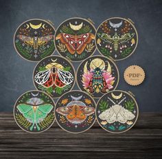 the moths are painted on wooden plates and placed in front of a chalkboard wall