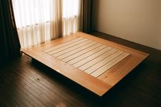 an empty room with wooden flooring and curtains