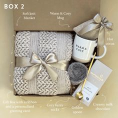 the contents of a gift box for someone's new baby, including blankets and mugs