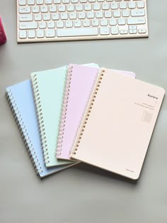 four notebooks are lined up next to a keyboard