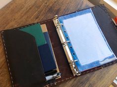 two notebooks sitting on top of a wooden table