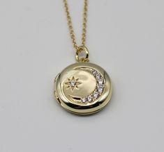 "This antique style locket is made of .925 sterling silver and plated in 14K gold.  It features a star and crescent moon lined in cubic zirconia stones.  It opens to hold two photographs. ~18\"  adjustable gold vermeil chain"