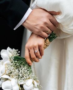 the bride and groom are holding each other's hands