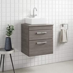 a bathroom sink sitting next to a white tiled wall