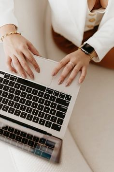 a woman is typing on her laptop computer