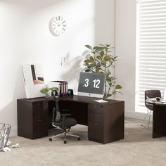 an office desk with a clock on the wall