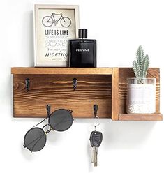 a wooden shelf with sunglasses, keys and other items hanging on the wall next to it