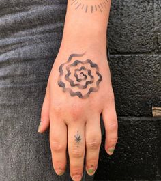 a woman's hand with a tattoo on it and a flower in the middle