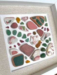 a white frame with many different colored rocks in it