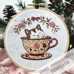 a cat is sitting in a teacup with flowers on it's head and the words hand embroideryery template