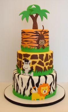 a three tiered cake decorated with animals and trees