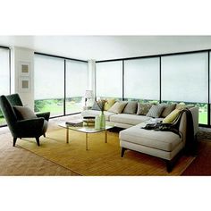 a living room filled with furniture and large windows covered in white roller shade coverings